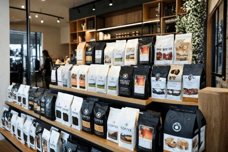 Retail shelf displaying different coffee packaging bags with branding and label designs for specialty coffee products